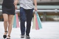 Cropped image of romance young Asian couple carrying colorful shopping bags on city street in weekend Royalty Free Stock Photo