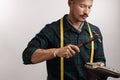 Cropped image of a shoemaker measuring a shoe with measure tape in workshop