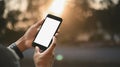 Cropped image of smart man`s hands holding a cropped black smartphone with white blank screen. Royalty Free Stock Photo