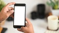 Cropped image of smart man`s hands holding a cropped black smartphone with white blank screen. Royalty Free Stock Photo