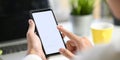 Cropped image of smart man`s hands holding and using a white blank screen smartphone. Royalty Free Stock Photo