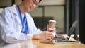 Cropped image of a smart young Asian male doctor reading a book at a cafe Royalty Free Stock Photo