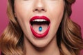 Cropped image of young lady with red lips holding pill in mouth Royalty Free Stock Photo