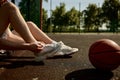 Cropped image of sportsman tying shoelaces sitting on basketball court