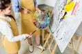 cropped image of teacher and pupil choosing paint on palette in workshop of Royalty Free Stock Photo