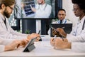 Cropped image of team of multiracial doctors using video screen projector during conference indoors, with their Royalty Free Stock Photo