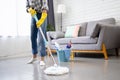 Cropped image of teenage girl holding a mop stick doing household chores is mopping the living room Royalty Free Stock Photo