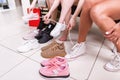 Cropped image of teenage girls trying on sports shoes in a shop