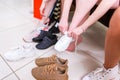 Cropped image of teenage girls trying on sports shoes in a shop