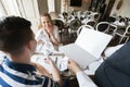 Cropped image of waiter showing menu to couple in restaurant