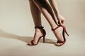 cropped image of woman adjusting stylish high heeled shoes