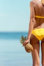 cropped image of woman in bikini holding pineapple Royalty Free Stock Photo