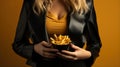 cropped image of woman in black jacket holding glass with french fries on yellow background Generative AI