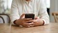 Cropped image of a woman using her smartphone at a table while relaxing in the coffee shop Royalty Free Stock Photo