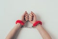 cropped image of woman hands in red fluffy handcuffs on white, valentines Royalty Free Stock Photo
