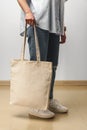 Cropped image of woman holding beige shopping bag in studio