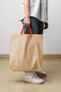 Cropped image of woman holding beige shopping bag in studio