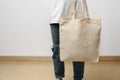 Cropped image of woman holding beige shopping bag in studio