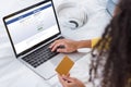 Cropped image of woman holding credit card and using laptop with facebook Royalty Free Stock Photo