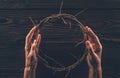 cropped image of woman holding crown of thorns