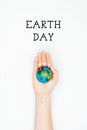 cropped image of woman holding earth model on hand under sign earth day