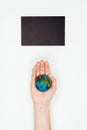 cropped image of woman holding earth model under blackboard