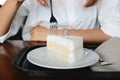Cropped image of woman holding fork with a peace of coconut cream cake. Royalty Free Stock Photo