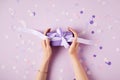 cropped image of woman holding present box at table with confetti pieces Royalty Free Stock Photo