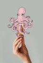 Cropped image of woman holding waffle ice cream cone with octopus