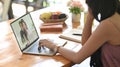 Cropped image woman is making a video call with her colleague while sitting in front of a computer laptop Royalty Free Stock Photo