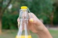 Cropped image of a woman while opening a cold bottle of lemonade in a hot day in the park