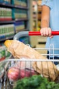 Cropped image of woman pushing trolley in aisle Royalty Free Stock Photo