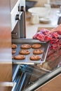 Cropped image of woman's hand removing cookie tray from oven in kitchen