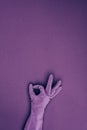 cropped image of woman showing ok sign in rubber protective glove