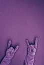 cropped image of woman showing rock signs in rubber protective gloves isolated on violet Royalty Free Stock Photo