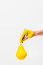 cropped image of woman in yellow paint holding pear in hand