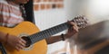 Cropped image of young asian woman practicing her skill on acoustic guitar. Royalty Free Stock Photo