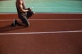 Cropped image of a young athletic man on track