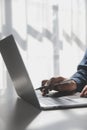 Cropped image of a young man working on his laptop in a coffee shop, rear view of business man hands busy using laptop at office Royalty Free Stock Photo