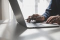 Cropped image of a young man working on his laptop in a coffee shop, rear view of business man hands busy using laptop at office Royalty Free Stock Photo