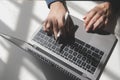 Cropped image of a young man working on his laptop in a coffee shop, rear view of business man hands busy using laptop at office Royalty Free Stock Photo