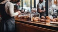 Cropped image of young woman in apron choosing pastry in cafe Generative AI