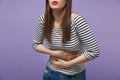 Cropped image of young woman in casual striped clothes posing isolated on violet purple background in studio. People Royalty Free Stock Photo