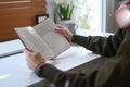 Cropped imaged of peaceful man reading favorite literature, spending leisure time in winter or autumn weekend at home