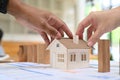 Cropped imaged of young couple holding. house model. Real estate investment, purchase and sale