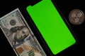 Cropped imageg of US 100 dollar bill, phone with green screen and ripple coin isolated on black Royalty Free Stock Photo