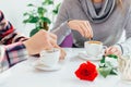 Perfect breakfast of romantic couple concept. Cropped insta shot of hands holding cups of coffee, beautiful flower and Royalty Free Stock Photo