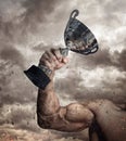 Cropped male arm with winner cup. Royalty Free Stock Photo