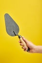 cropped male holding spatula in hands, for cleaning a concrete wall from defects, repair and construction Royalty Free Stock Photo