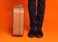 Cropped of male legs next to stylish suitcase